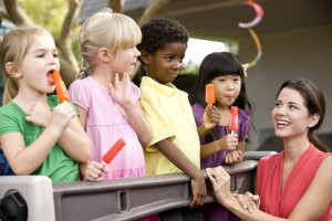 Group young preschool children playing in daycare with teacher