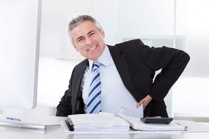 Man at desk with hurt back